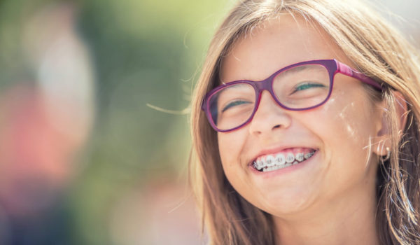bambina sorridente con apparecchio ortodontico