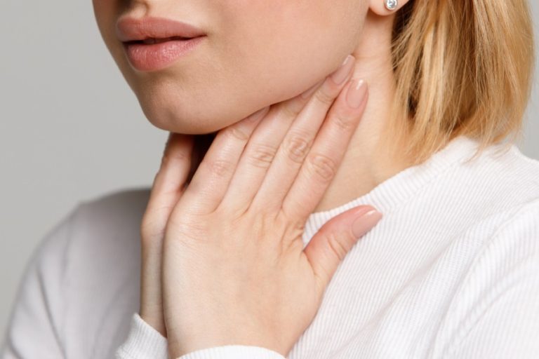 bambina che si tocca il collo e sente dolore a cause di una infiammazione al dente che le ha causato i linfonodi ingrossati