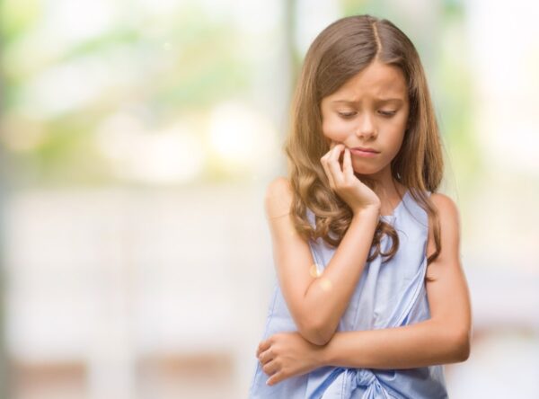 bambina con un problema di afte in bocca