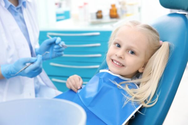 bambina felice che fa la visita dall'ortodontista perché ha avuto un problema di frattura del dente