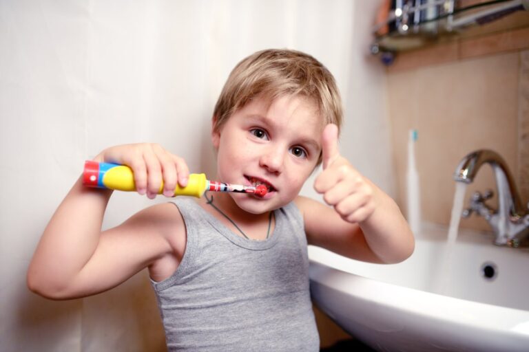 bambino che utilizza il suo spazzolino elettrico per lavare i denti